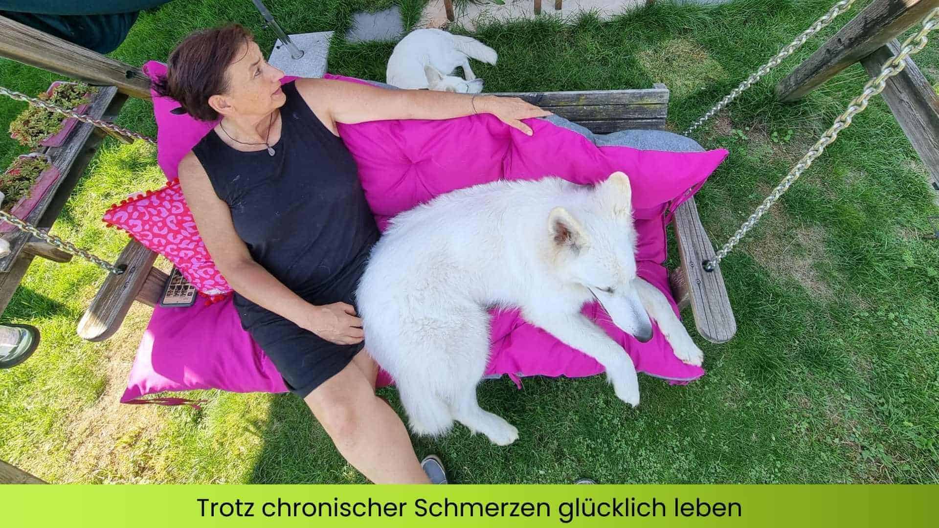 Marianne sitzt mit weißem Schäferhund in der Hängeschaukel und genießt den Moment, trotz chronischer Schmerzen