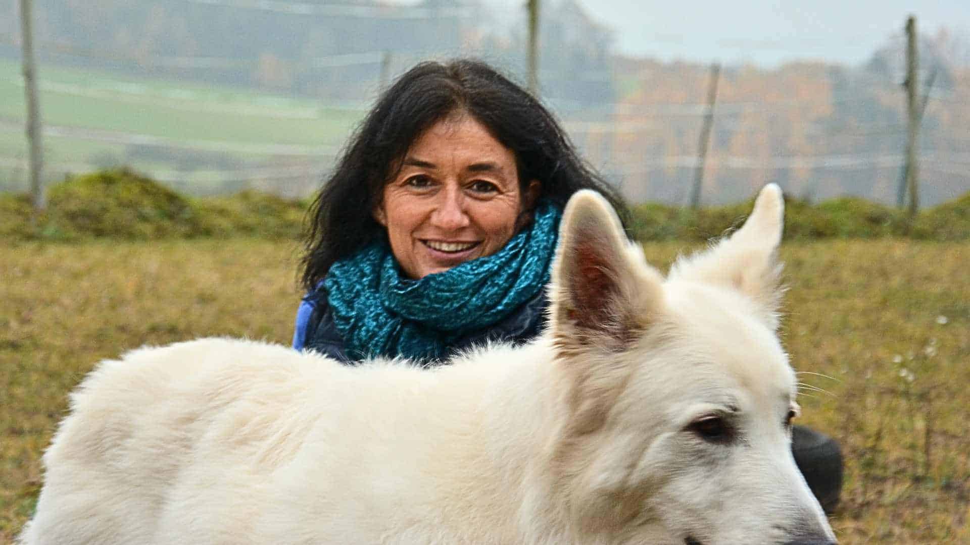 Marianne mit einem weißen Schäferhund in der Natur