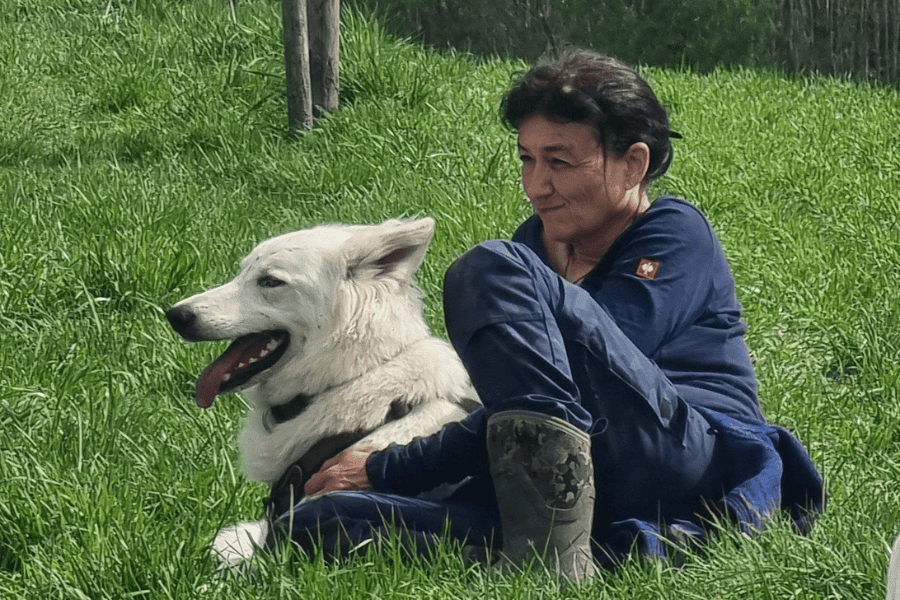 Marianne mit Kalani nachdenklich auf einer Wiese sitzend