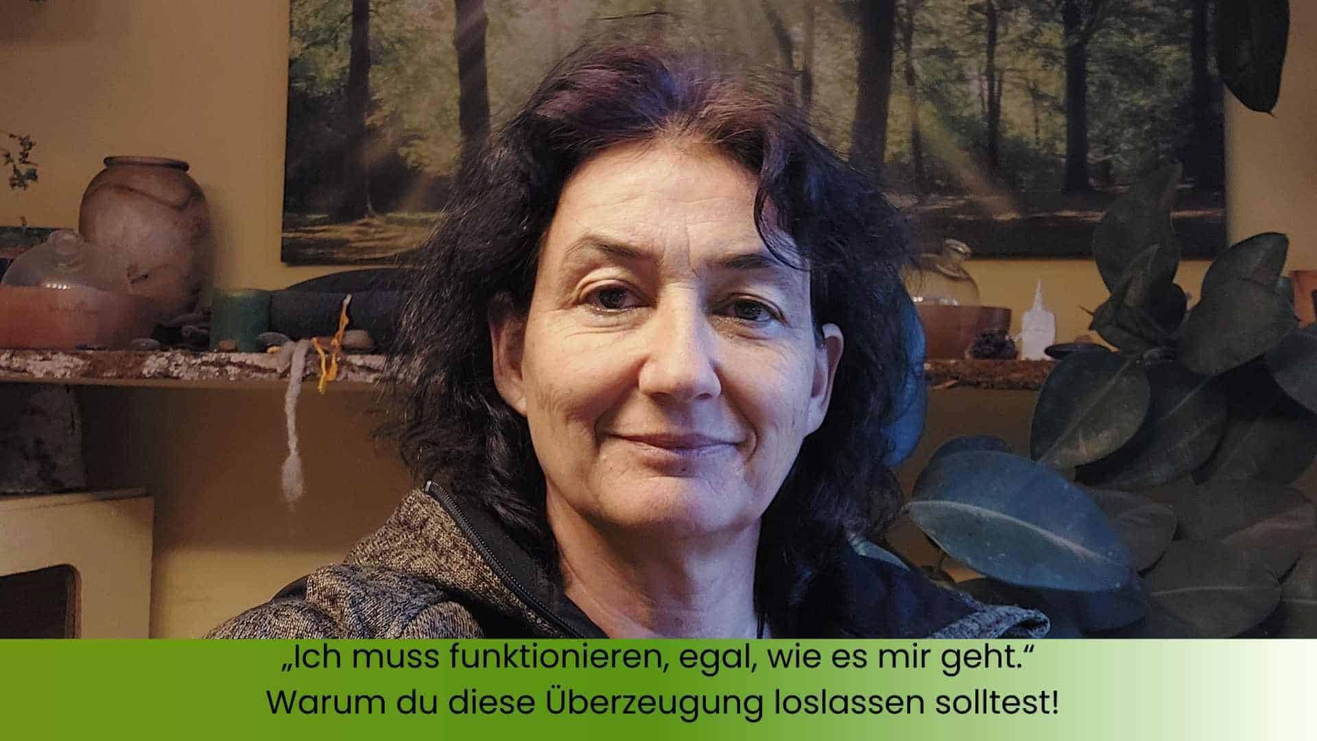 Marianne in ihrem Büro vor dem Hausaltar im Hintergrund mit Edelsteinen, Trommel usw.